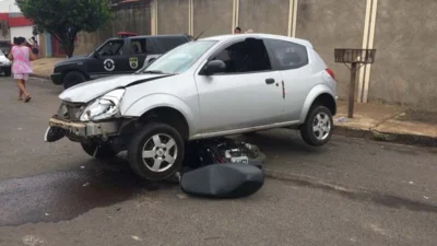 Motocicleta para embaixo de carro após acidente