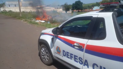 Defesa Civil combate incêndio em entulhos jogados em terreno baldio